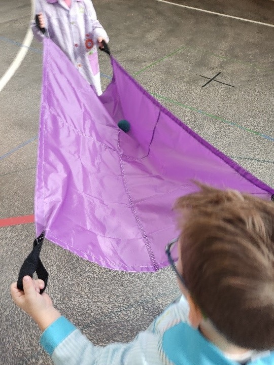 niños transportando objetos con paracaídas infantil